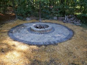 Brick fire pit with metal ring and round paver patio